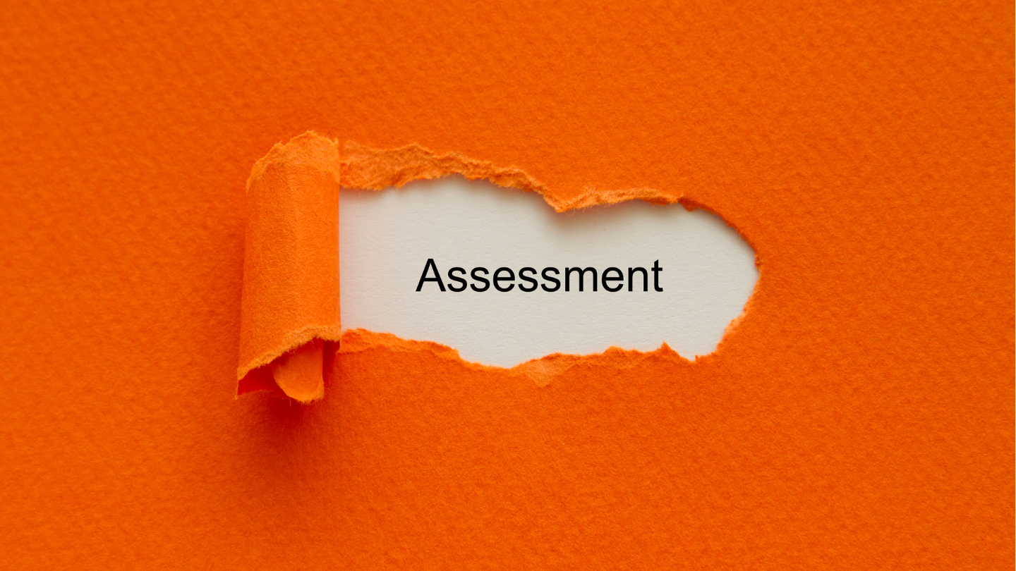 a paper peeling off revealing the word 'assessment' behind