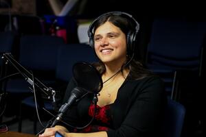 Lindsay Morcom in the recording studio with a microphone and headphones