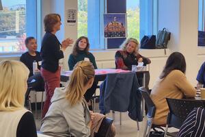 A woman speaking to a group of listeners