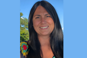 Jennifer, with long shiny black hair is smiling at the camera. 