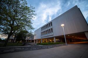 Exterior of Duncan McArthur Hall at night in the spring with one street lamp on.