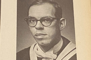 Dennis Quinn in a yearbook photo wearing glasses.