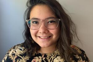 A woman with glasses and a shirt with a floral design