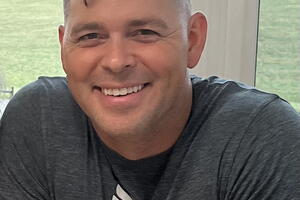 A man sits at a table and smiles