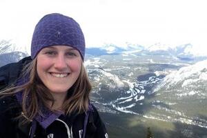 Brooke smiling at camera while look out on a mountain landscape
