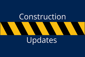 A blue background with construction tape and the words construction updates across it 