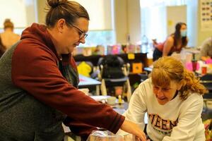 Two students settung up a class project to present in front of their peers.