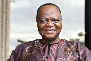 George Dei smiles outside.