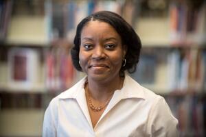 Alana Butler smiling at camera in a library