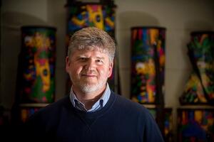 Ben Bolden smiles with a background of colourful pillars.