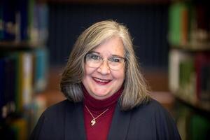 Lynda Colgan smiles in a hallway.