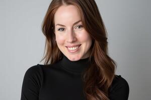 A woman with long brown hair wearing a turtle neck 
