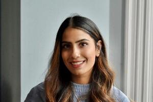 An Indian woman wearing a blue sweater