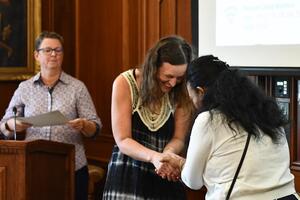 Career Gateway program graduation featuring a woman shaking another woman's hand.