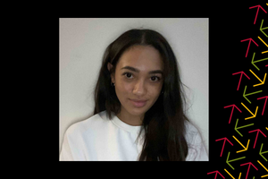 Mandy Taylor smiles against a white wall wearing a white shirt. There is a black border with red, yello, and green arrows overlayed on the right side.