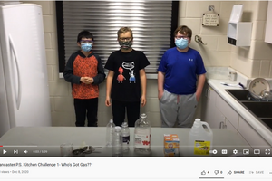 Screenshot from a Youtube video showing students doing a science experiment in a kitchen.