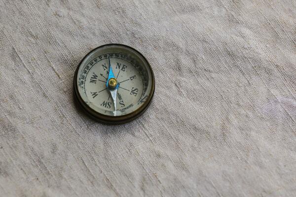 A compass sits on a piece of fabric