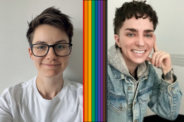 Two people look at the camera with a rainbow ribbon between them. 