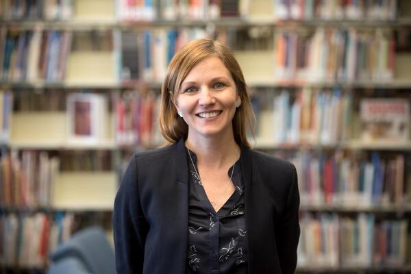 A white woman smiling at the camera wearing a blazer