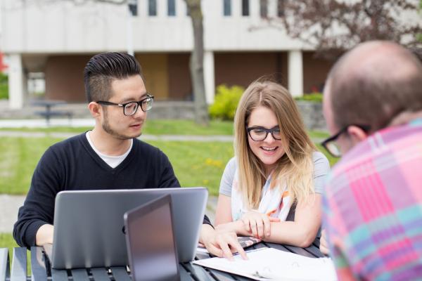 students working outside on a laptop