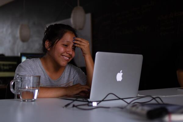 Girl smiling at laptop.