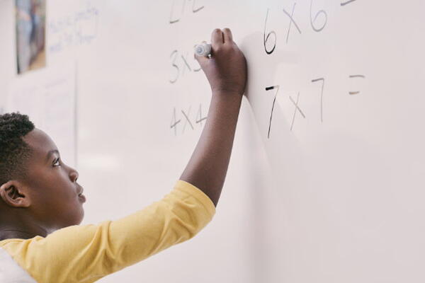 a student writing on a whiteboard