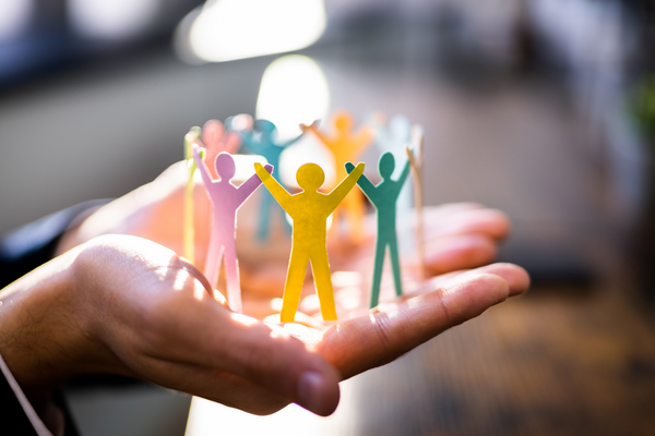 A person holding paper origami showing a group of people together