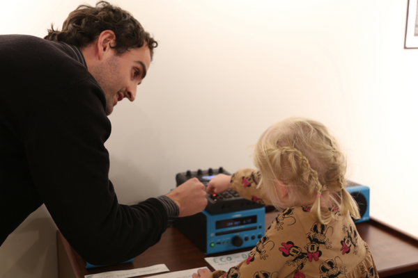 A man teaching a small child at a workstation