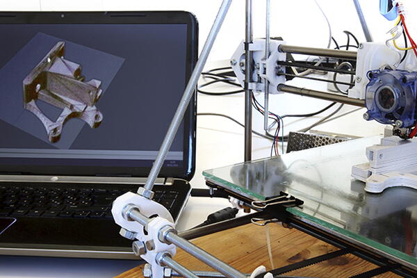 a machine and laptop in a robotics lab