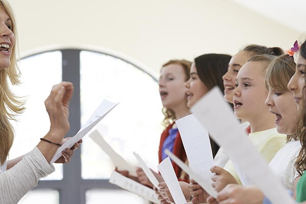 a group of students with a teacher practicing singing