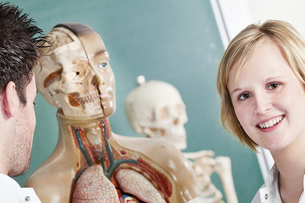 a group of people with a skeleton model in a lab