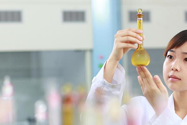 a person holding a beaker in a chemistry lab