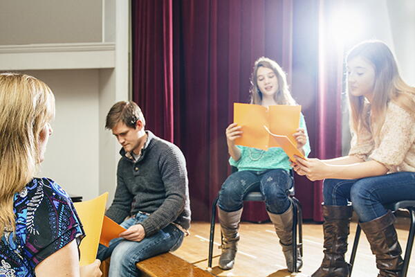 a group of students practicing a stage play