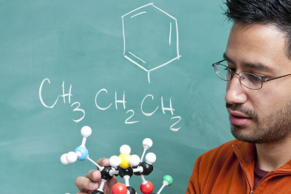a person holding a chemistry diagram of a compound