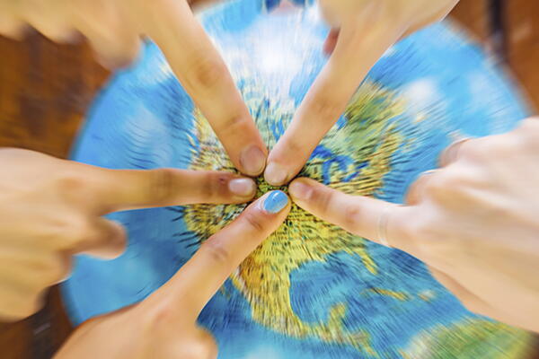 a group of people pointing at a globe