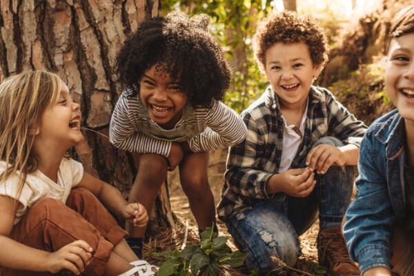 a group of kids laughing in the woods