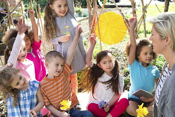 a teacher with students sitting in a park