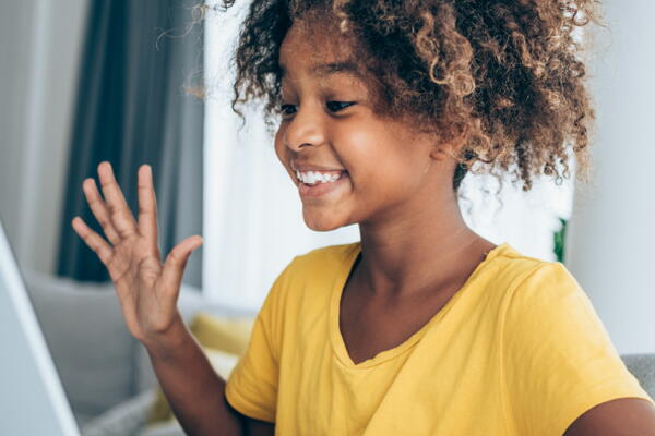 a child smiling while using a laptop