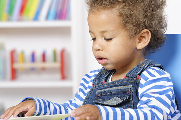 a child reading a book in a classroom