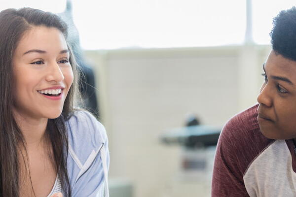 two people sitting together and talking
