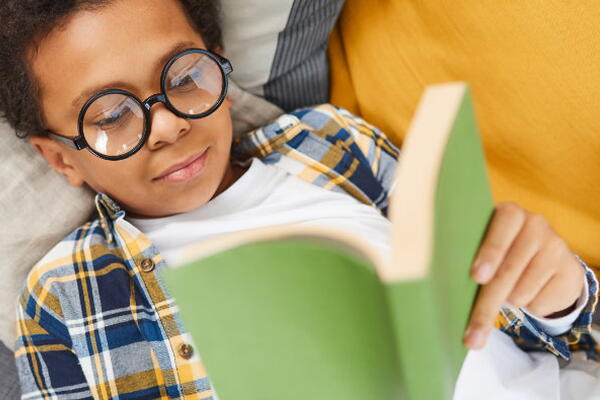 a child laying down reading a book