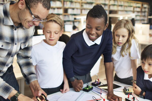 a professor working on circuit boards with their students 