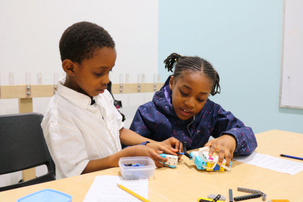 Two children creating a Lego structure at the Robotics lab