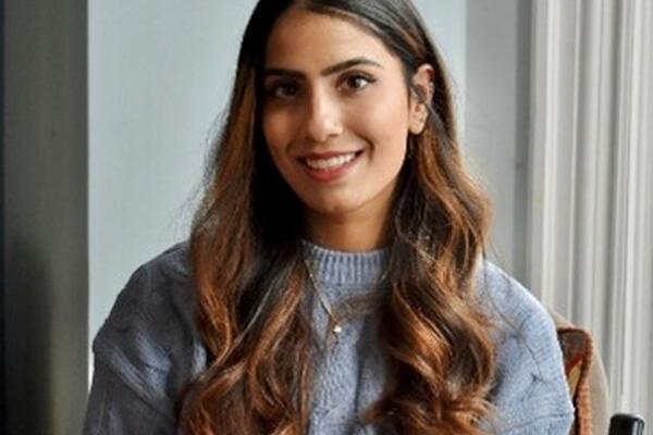 An Indian woman wearing a blue sweater