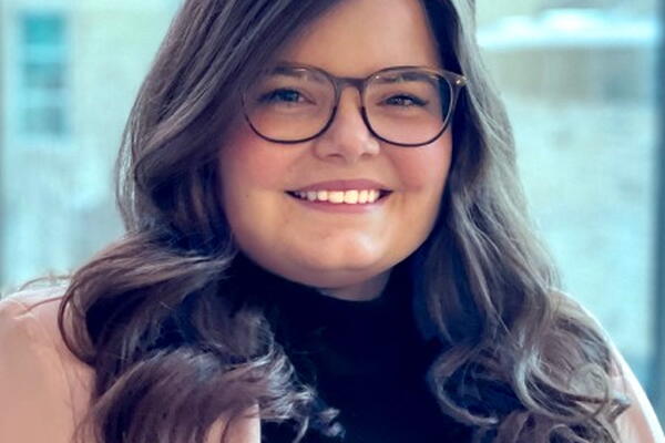 The image features Rebecca Leclair, a white woman, wearing glasses, and with long dark hair.