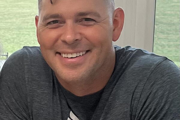 A man sits at a table and smiles