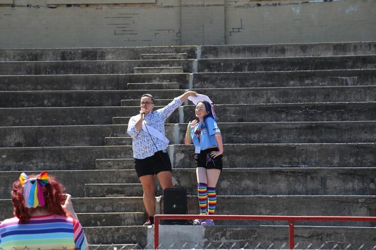Lee Airton wearing a tiara and sash next to Bee who is wearing a blue shirt and rainbow socks