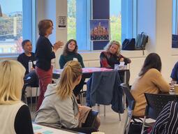 Woman speaking to a group of attentive listeners