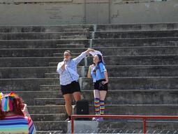 Lee Airton wearing a tiara and sash next to Bee who is wearing a blue shirt and rainbow socks