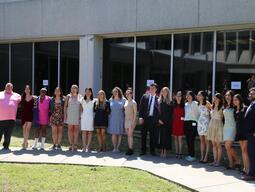 The graduates of 2021 stand in a row smiling.